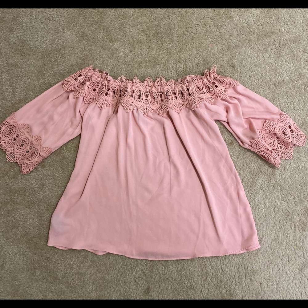 A pink off the shoulder blouse with a lace trim